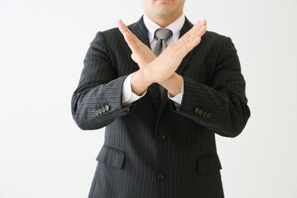 NGハンドサインをしている人の画像