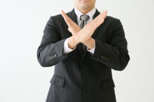 NGハンドサインをしている人の画像