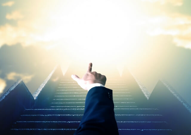 階段と前を指差すビジネスマン